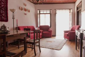 a living room with a table and red chairs at Casa Do Peirão in Varge