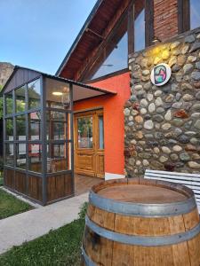 Um edifício com um barril à frente. em Hotel Lunajuim em El Chaltén