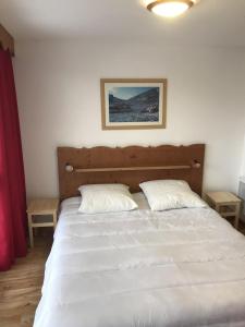 a bedroom with a white bed with two pillows at V du Bachat Asters B21 - Appt 6 pers in Chamrousse