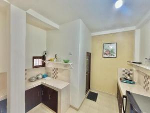 ElagawagodaにあるRanu Villa kathaluwaの白い壁のキッチン(カウンタートップ付) +6枚の写真