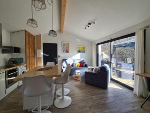 cocina y sala de estar con mesa y sillas en PAUSE NATURE. Maison Ananda à 14 kms de Toulouse avec parking privatif, en Lapeyrouse-Fossat