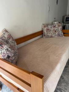 1 cama con marco de madera y almohadas en Alquiler en el CENTRO Luz en Río Gallegos