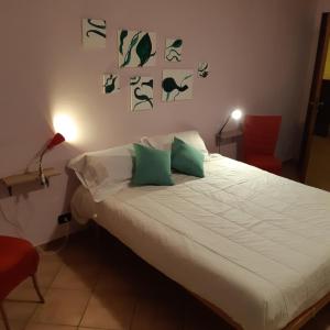 a bedroom with a bed with green pillows at Casa Olimpia in Priocca
