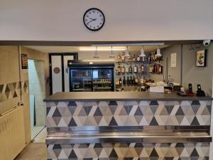 eine Bar mit einer Uhr an der Wand darüber in der Unterkunft Hotel Djerdan in Kraljevo + 14 Fotos