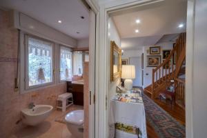 a bathroom with a sink and a toilet and a staircase at tosca house 2 in Varenna