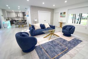 een woonkamer met twee blauwe stoelen en een tafel bij Villa Cristina in Miami in Miami