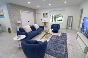 een woonkamer met een blauwe bank en stoelen bij Villa Cristina in Miami in Miami