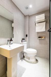 La salle de bains est pourvue de toilettes blanches et d'un lavabo. dans l'établissement U STAY MyeongDong, à Séoul
