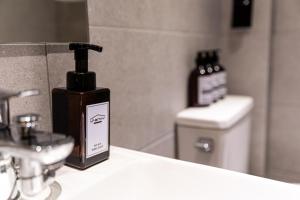 a bottle of soap sitting on a counter in a bathroom at U STAY MyeongDong in Seoul