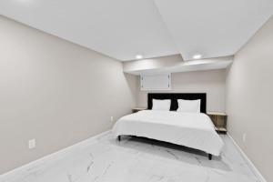 LUX White Marble Retreat near NYC في بايون: غرفة نوم بيضاء بسرير وجدار ابيض