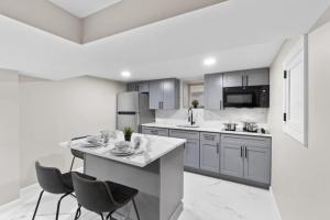 LUX White Marble Retreat near NYC في بايون: مطبخ فيه طاولة وكرسيين +9 صور