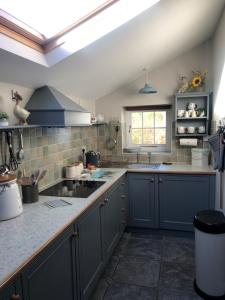 a kitchen with blue cabinets and a sink at the old rectory cottage in Pwllheli