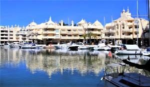 a marina with boats docked in front of a large building at Frontline Benalmadena Marina Apartment in Benalmádena