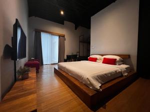 a bedroom with a large bed with red pillows at Rumah Kahyangan in Canggu