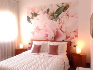 a bedroom with a bed with a flower painting on the wall at tosca house 2 in Varenna