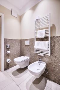 een witte badkamer met een toilet en een wastafel bij Hotel Jarolim in Bressanone