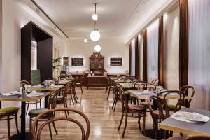 un ristorante con tavoli, sedie e orologio di Hotel Jarolim a Bressanone