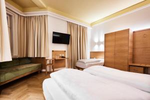 um quarto de hotel com duas camas e uma televisão de ecrã plano em Hotel Jarolim em Bressanone