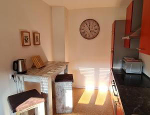 a kitchen with a table and a clock on the wall at Ferienwohnung Wiesenblick in Illingen