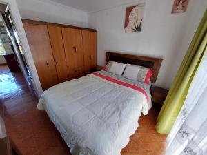 1 dormitorio con 1 cama con cabecero de madera en Hospedaje Flover, en Puerto Varas