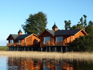 una gran casa de madera en el borde del agua en Gracias a la Vida Lodge, en Puerto Varas