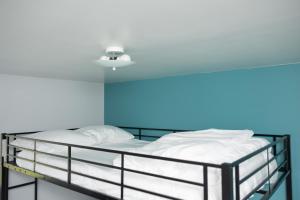 een bed in een kamer met een blauwe muur bij Sapphire Suite Near NYC in Bayonne