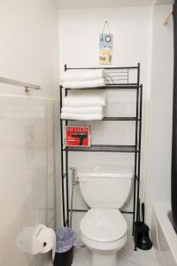 a bathroom with a toilet and a rack with towels at Sapphire Suite Near NYC in Bayonne
