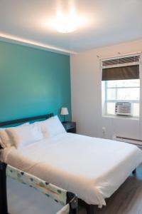 a bedroom with a large bed with a blue wall at Sapphire Suite Near NYC in Bayonne