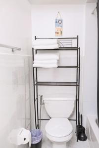 een badkamer met een toilet en een rek met handdoeken bij Sapphire Suite Near NYC in Bayonne