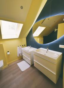 Baño con 2 lavabos y espejo en The Treehouse Gistel, en Gistel