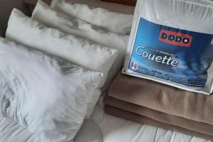 a bag ofoatmeal sitting on a bed with white pillows at Appartement VERCORS 4 personnes in Autrans
