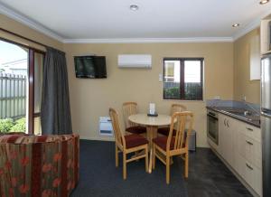 a kitchen with a table and chairs in a kitchen at Blenheim Spa Motor Lodge in Blenheim
