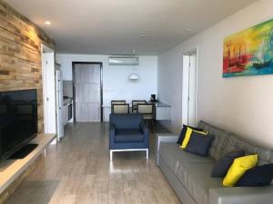 マセイオにあるFLAT ENCANTADOR PÉ NA AREIA 2 SUÍTES- WATERFRONTのソファとテレビのあるリビングルーム