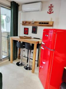 cocina con nevera roja y mesa de madera en LE FLORIDE B Folco de baronchelli en Le Grau-du-Roi