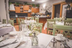 uma mesa com pratos brancos e flores num restaurante em Penzion Prinz em Valtice