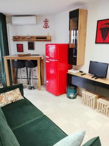 a living room with a red refrigerator and a desk at LE FLORIDE B Folco de baronchelli in Le Grau-du-Roi