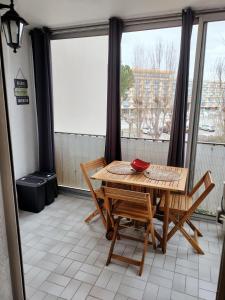 a dining room with a table and chairs on a balcony at LE FLORIDE B Folco de baronchelli in Le Grau-du-Roi