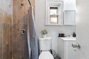 uma casa de banho branca com um WC e um chuveiro em Whimsical three em Bayonne