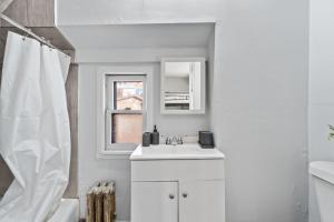 a white bathroom with a sink and a shower at Whimsical Two in Bayonne