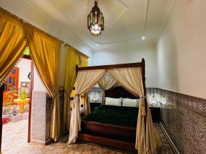 - une chambre avec un lit à baldaquin et un lustre dans l'établissement Dar Al Fassia, à Oujda