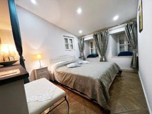a bedroom with a bed and two windows at Apartment Saraka in Dubrovnik