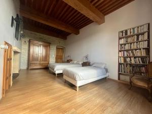 a bedroom with two beds and a book shelf at Gîte Entre Sources et Sapins 