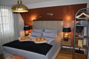 a bedroom with a bed with two pillows on it at Hotel Belvedere in Warnemünde