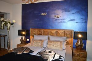 a bedroom with a bed with a blue wall at Hotel Belvedere in Warnemünde