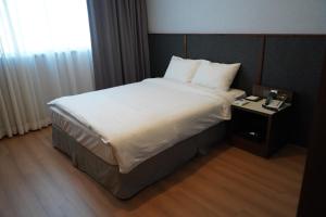 sypialnia z dużym łóżkiem i stolikiem nocnym w obiekcie Sacheon Grand Tourist Hotel w Sacheon