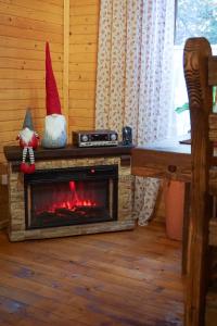 a room with a fireplace with two gnomes and a table at Na Penkah in Yaremche