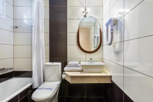 a bathroom with a toilet and a sink and a mirror at Iris Hotel in Siviri