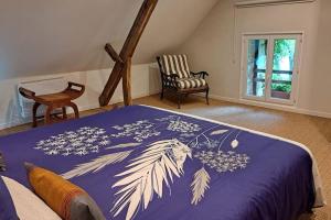 a bedroom with a bed with a purple comforter at Chaumière de Kerréo, ELISA in Pluvigner