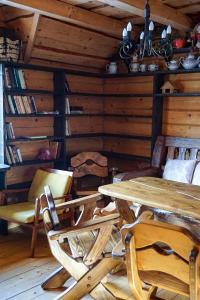 a dining room with a table and chairs and books at Na Penkah in Yaremche