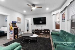 a living room with a green couch and a flat screen tv at Modern Dream Loft in Bayonne